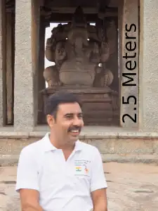 Indien Reiseleiter steht vor dem Ganesha-Gott in Hampi. Ganesha-Figur ist 2.5 Meters hoch.